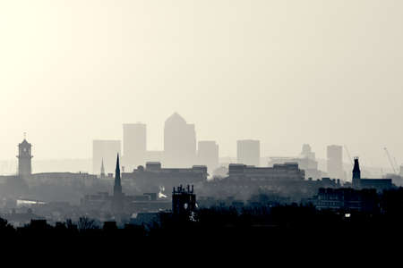 Gotham Retro Photo Filter - London Cityscape at Sunrise with early morning mist from Hampstead Heath looking towards Canary Wharf, England, UK.の写真素材