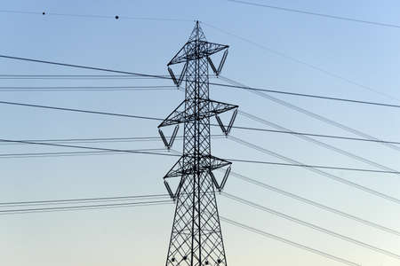 Power line: a pylon with cables at evening in Italy