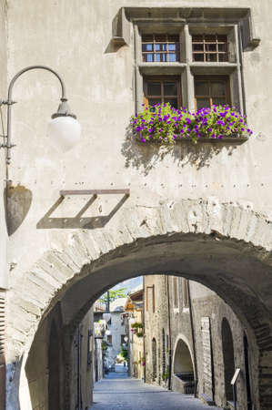 Bard  Aosta, Italy  - Street of the medieval village with arch and flowered windowの写真素材