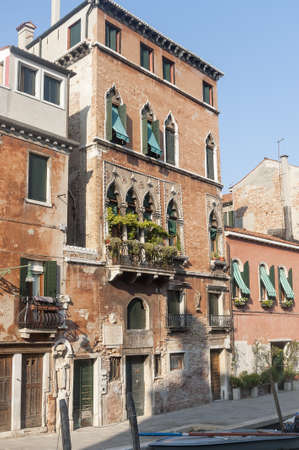 Venice (Venezia, Veneto, Italy), old typical buildings on a canal and boatの写真素材