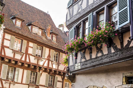 Colmar (Haut-Rhin, Alsace, France) - Exterior of old half-timbered houses with flowers at windowsの写真素材