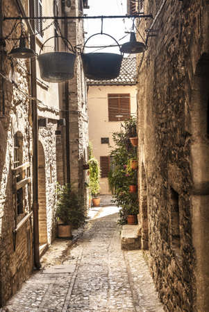 Spello (Perugia, Umbria, Italy) - Typical alley with arch and two hanged potsの写真素材
