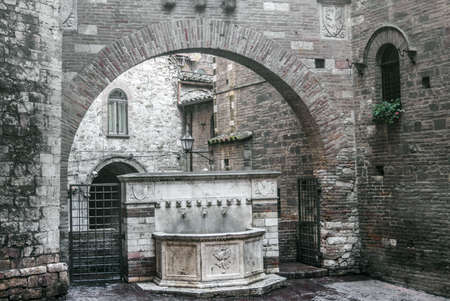 Perugia (Umbria, Italy) - Old marble fountain and arch.の写真素材