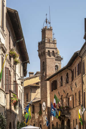 Buonconvento (Siena, Tuscany, Italy) - Historic buildings with clock tower and colorful flagsの写真素材