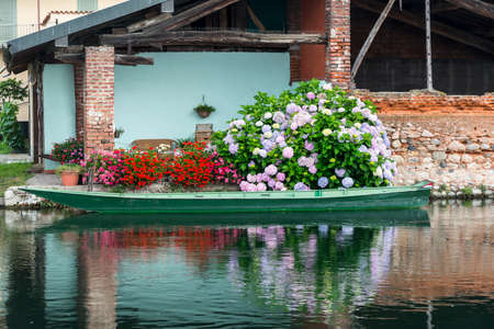 Bernate (Milan, Lombardy, Italy), typical old houses, boat and flowers along the Naviglio Grandeのeditorial素材