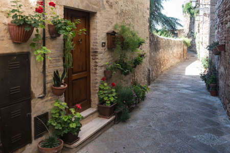 Colle di Val d'Elsa (Siena, Tuscany, Italy), historic city. Old houses with potted plants and flowersの写真素材