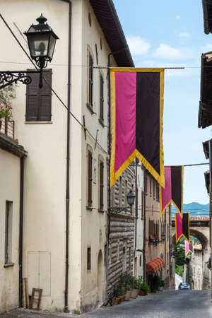 Cagli (Pesaro e Urbino, Marches, Italy), a typical old street with flagsのeditorial素材