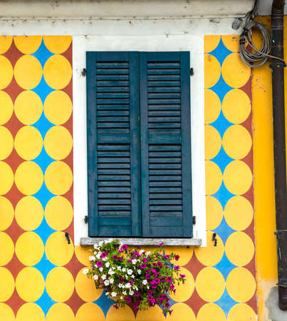 Old house in Gaggiano (Milan, Lombardy, Italy), along the Naviglio Grande. Windows with flowersのeditorial素材