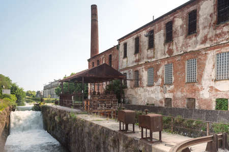 Cascade along the Naviglio Pavese, canal between Milan and Pavia (Lombardy, Italy), and old industrial buildingsの写真素材