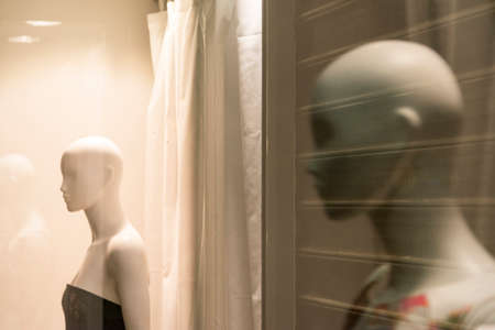 Shop window at Narbonne (Aude, Languedoc-Roussillon, France) with two mannequins by nightの写真素材