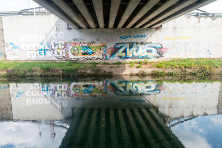 Graffiti under a bridge over the Naviglio Pavese, canal between Milan and Pavia (Lombardy, Italy)の写真素材
