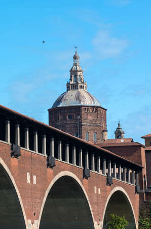 Pavia (Lombardy, Italy): the famous covered bridge over the Ticino river and the cathedral domeの写真素材
