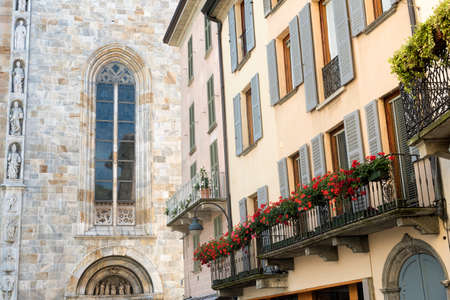 Como (Lombardy, Italy): exterior of the cathedral, built from the 13th century, and historic residential buildings with plants and flowersのeditorial素材