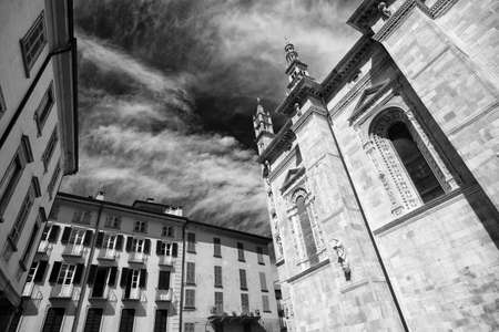 Como (Lombardy, Italy): exterior of the cathedral, built from the 13th century, and historic residential buildings with plants and flowers. Black and whiteの写真素材