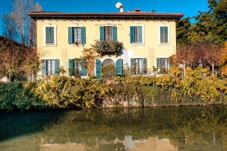 Milan (Lombardy, Italy): road for pedestrians and bicycle along the canal of Martesana. Facade of historic houseの写真素材