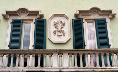 Saronno (Varese, Lombardy, Italy): green facade of historic palace, with windows and balcony