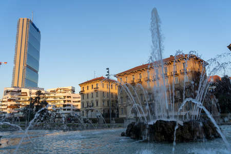 Milan, Lombardy, Italy: Citylife at sunset with old fountain in foregroundの写真素材