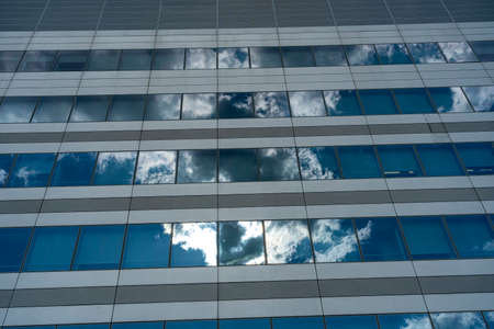 Milan, Lombardy, Italy: clouds reflected on the facade of a modern palace in the Portello parkの写真素材