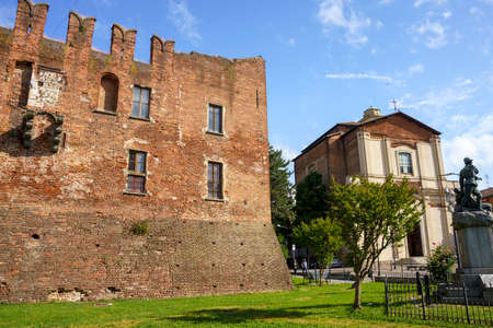 Exterior of medieval castle in Binasco, Milan province, Lombardy, Italy, known as Castello Visconteo, and churchのeditorial素材
