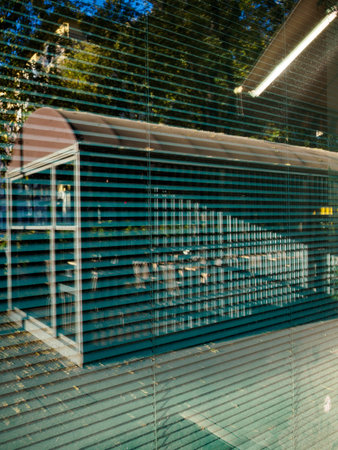 Reflections in a shop window along via Biondi in Milan, Lombardy, Italy