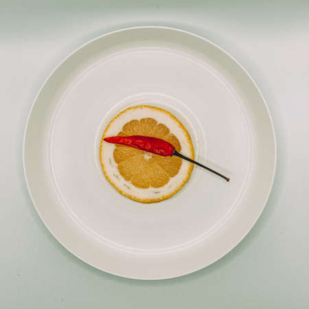 Still life: lemon and pepper on a white plateの写真素材