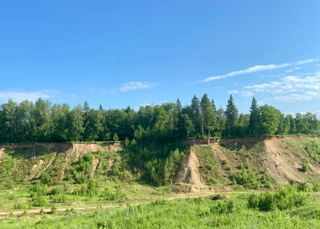 A cliff of an abandoned sand quarry and forest