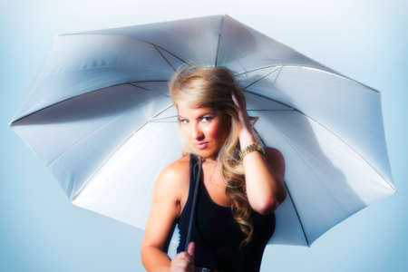 Blonde Latina girl holding umbrella. Stylized silver and blueの写真素材
