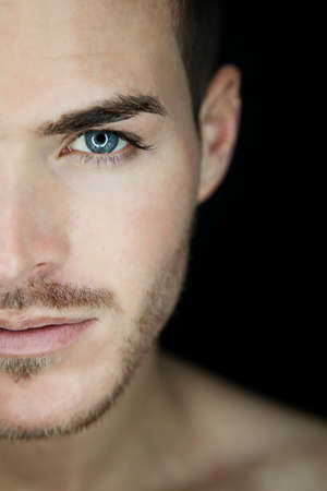 Portrait of a beautiful young man half faceの写真素材