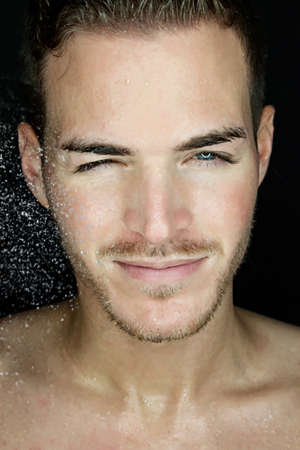 Portrait of a beautiful young man with wet face