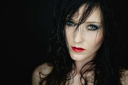 Portrait of a beautiful young woman with red lipstick and wet hair