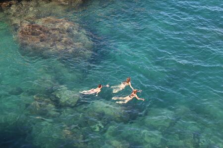 Silhouettes that swim in blue and crystal clear waterの写真素材