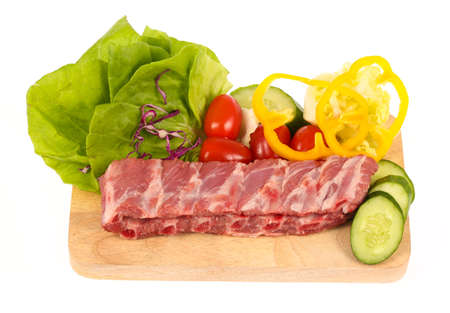 pork ribs on cutting board with vegetable isolated on white backgroundの写真素材