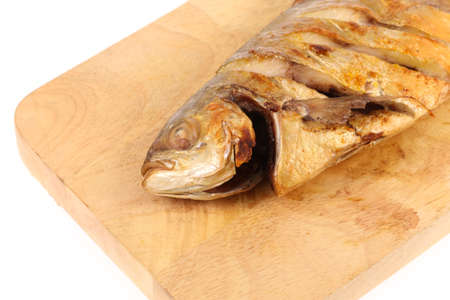 Grilled fish on chopping block isolated on white background