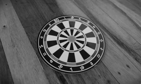 Black and white photo of darts isolated on a wood background