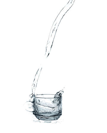 pouring water splash into glass isolated on white backgroundの写真素材