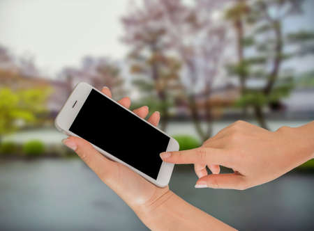 Businessman using smart phone against tree green backgroundの写真素材