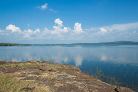 Beautiful river landscape with stones on blue sky backgroundの写真素材