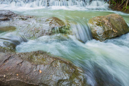river background with small waterfalls in tropical forest.
