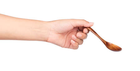 hand holding wood spoon isolated on white background.の写真素材