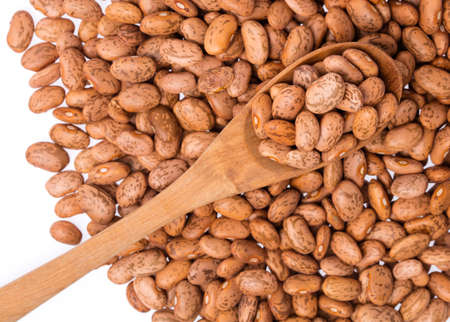 Pinto beans with wood spoon in heap of beans background