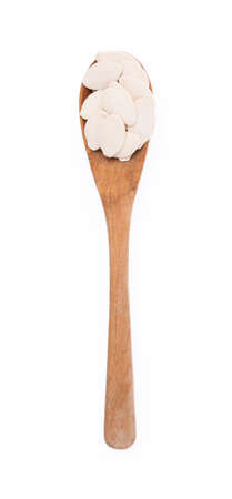 Wood spoon of Pumpkin seeds isolated on white backgroundの写真素材