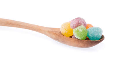 colorful jellys on a wood spoon isolated on white backgroundの写真素材