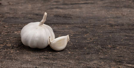 fresh garlic isolated on wood backgroundの写真素材