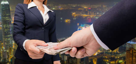 business woman and a businessman hold money