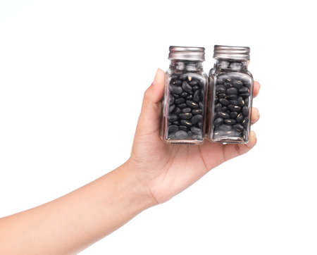 hand holding bottle of black beans isolated on white backgroundの写真素材