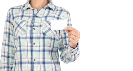 girl dressed in plaid shirt showing a business card isolated on white background