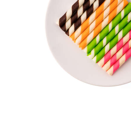 dish of Striped wafer rolls isolated on white backgroundの写真素材