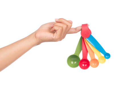 hand holding measuring spoons isolated on white backgroundの写真素材