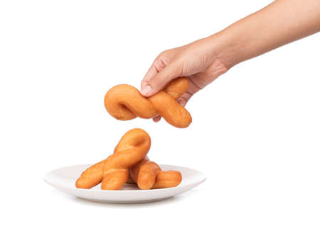 hand holding deep-fried dough stick on plate isolated on white background.の写真素材