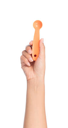 hand holding measuring spoons isolated on white backgroundの写真素材